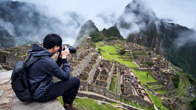Viajero fotografiando la ciudadela de Machu Picchu