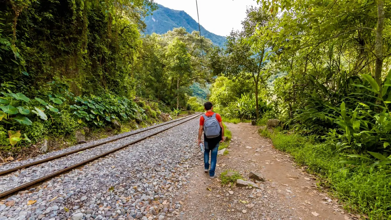 Caminante junto a la vía del tren hacia Aguas Calientes