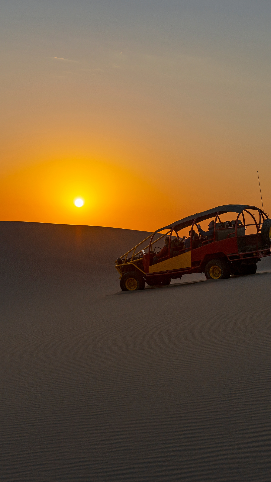 Atardecer dorado sobre las dunas en el Tour en Buggy & Sandboarding en Huacachina.